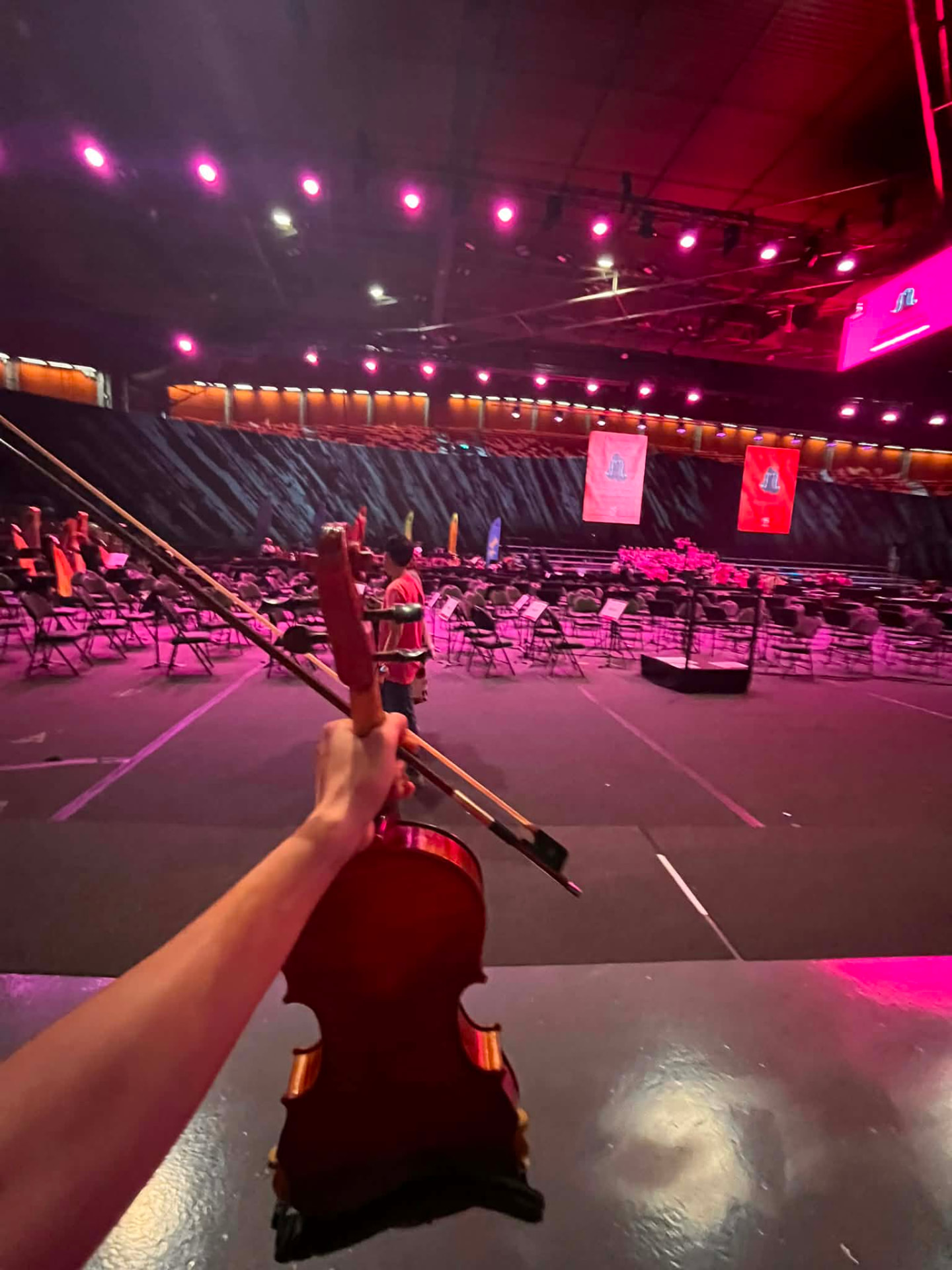 Violin och stråke lyfts mot en konsertarena före repetition