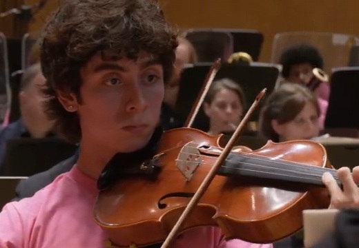 Violinist spelar under en orkesterrepetition